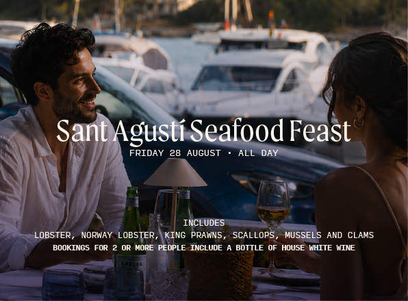 Personas disfrutando de una mariscada en HPC frente a la bahia de portocolom. 